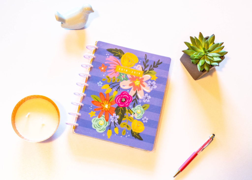 colorful floral Happy Planner flatlay with bird decoration candle succulent and pink pen