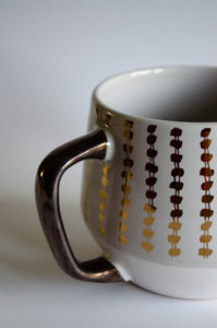 macro shot of gold and bronze decorative coffee mug