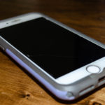 white iphone with purple and gray case