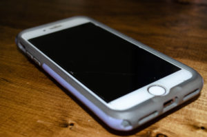 White Iphone with purple and gray case