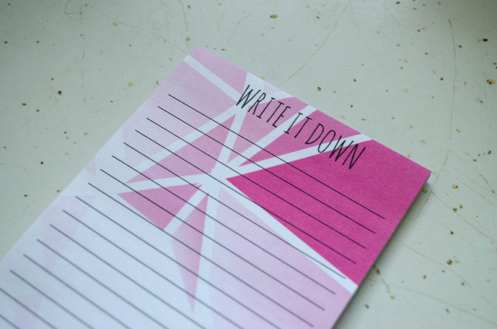 A pink groemetric patterned list pad with the title "write it down"