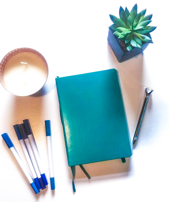Teal notebook with markers candle pen and succulent