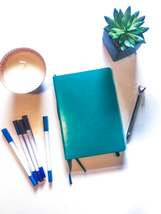 Teal notebook with markers candle pen and succulent