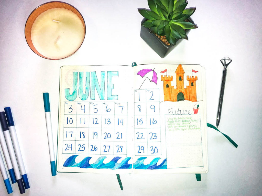 Bullet journaling spread june calendar with markers candle succulent and pen