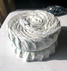 first layer of diaper cake outside of pan and secured with rubber bands