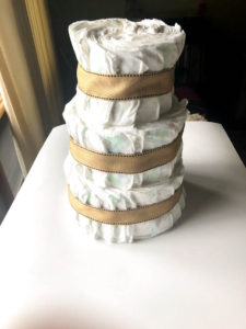 all three layers of diaper cake stacked with ribbon attached to cover rubber bands